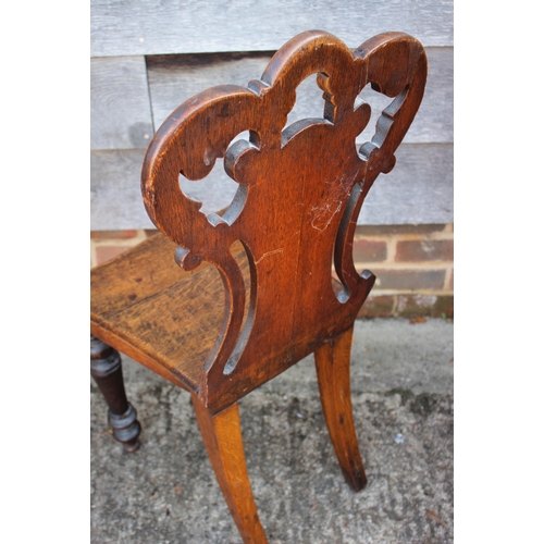 538 - A 19th century carved oak hall chair with panel seat, on shaped supports