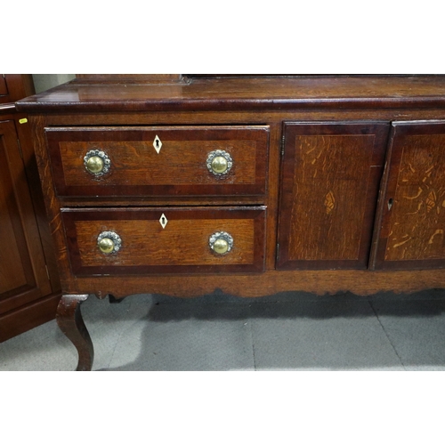 540 - An early 19th century oak and mahogany banded dresser, the upper section fitted open shelves with fl... 