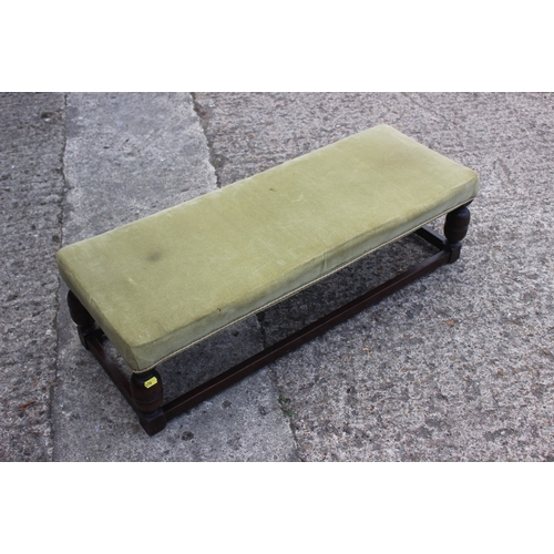 578 - An oak framed fender stool, upholstered in a green velour, on turned and stretchered supports, 39