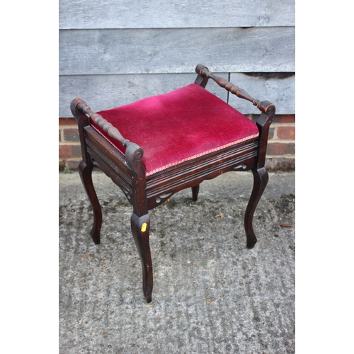 583 - An early 20th century walnut piano stool with box seat upholstered in a red velour, on cabriole supp... 