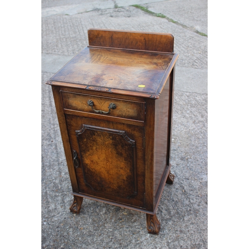 586 - A 1930s figured walnut ledge back bedside cupboard, fitted one drawer, on claw and ball shaped carve... 