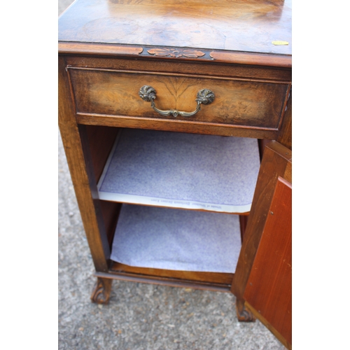 586 - A 1930s figured walnut ledge back bedside cupboard, fitted one drawer, on claw and ball shaped carve... 