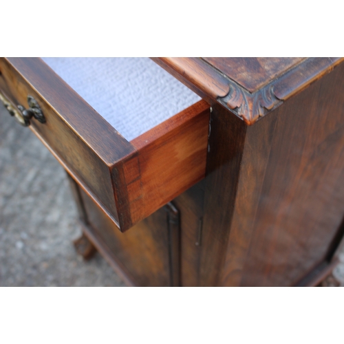 586 - A 1930s figured walnut ledge back bedside cupboard, fitted one drawer, on claw and ball shaped carve... 