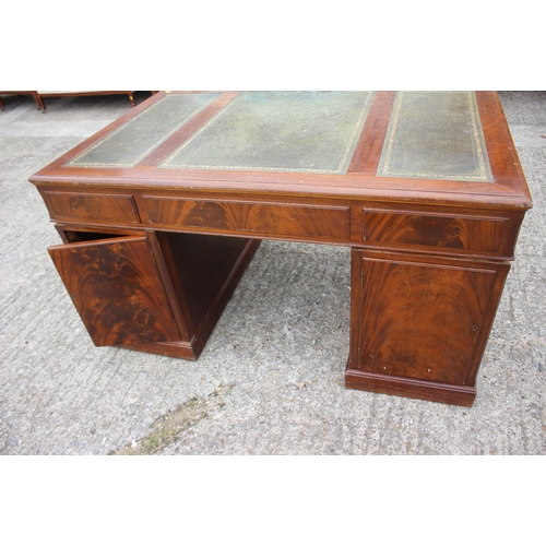 591 - A partners figured mahogany double pedestal desk with triple panel tooled leather top over nine draw... 