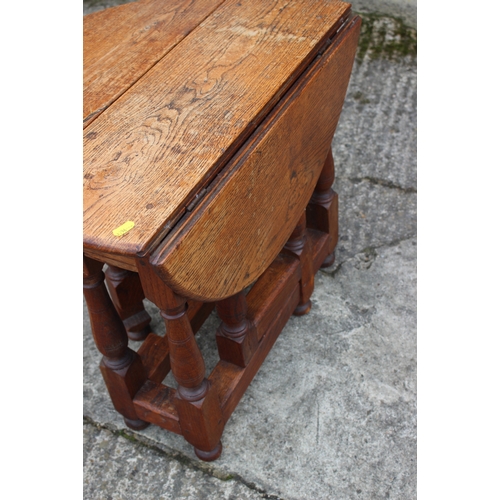 602 - An oak drop leaf occasional table, on turned and stretchered supports, 23