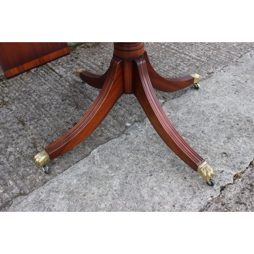 605 - A mahogany and yew wood banded single pedestal extending dining table, 42