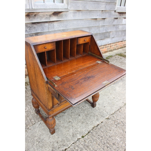 606 - An oak fall front bureau with fitted interior over two long drawers, on turned and stretchered suppo... 