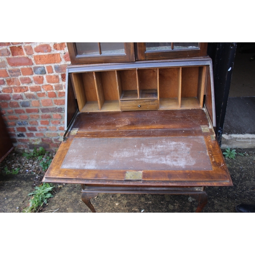 626 - An early 20th century walnut and banded bureau bookcase, the upper section enclosed two doors over f... 