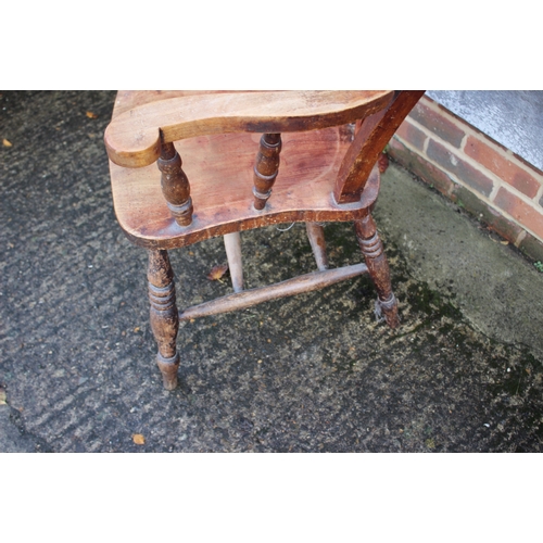 628 - A Windsor farmhouse lathback elbow chair with panel seat on turned and stretchered supports