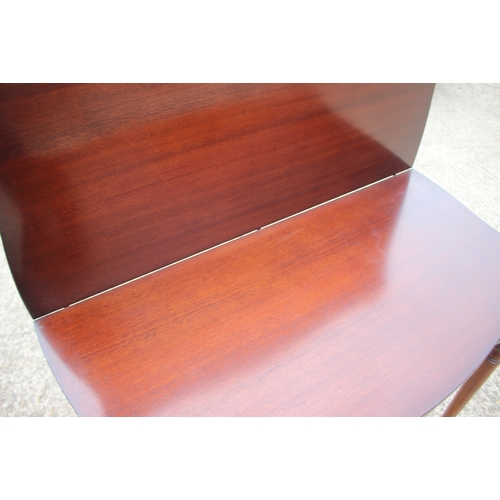 631 - A mahogany and serpentine front fold-over top desk/tea table, on turned and tapering supports