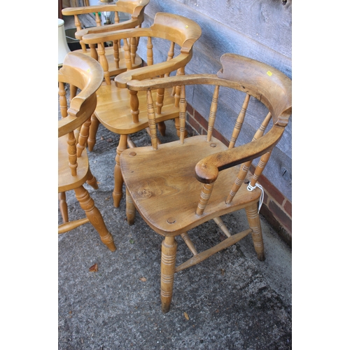 635 - A set of four beech spindle back elbow chairs with panel seats, on turned and stretchered supports