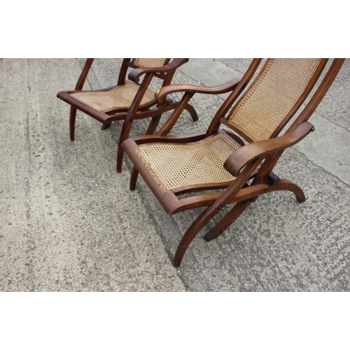 647 - A pair of Edwardian teak and cane seat and back folding steamer chairs