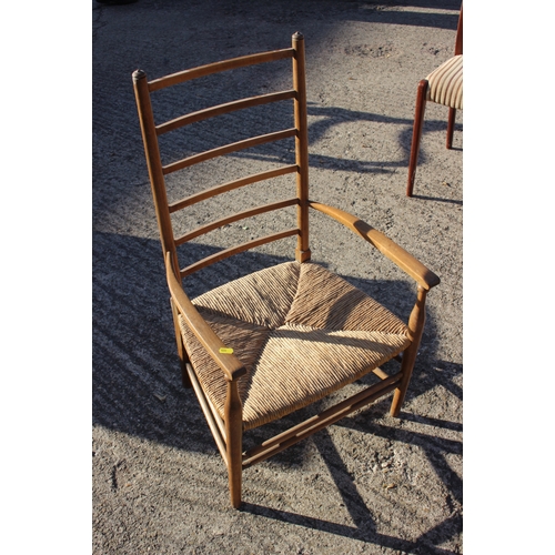 650 - An Arts & Crafts ash ladder back elbow chair with rush seat, on turned and stretchered supports