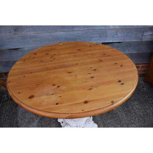 667 - A circular pine top table on cast iron column and weighted base, 42