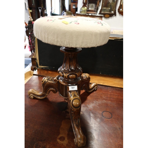 587 - An early 20th century carved walnut circular seat piano stool, on tripod splay support (adjustable m... 