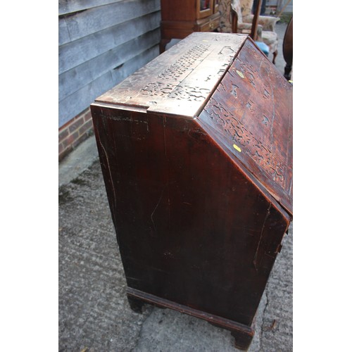 484 - A carved fall front bureau with fitted interior over three graduated drawers on bracket feet, 36