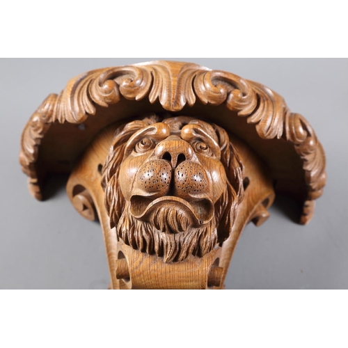 208 - A carved wall bracket, formed as a lion's head with scrolls and talon, 18 1/4