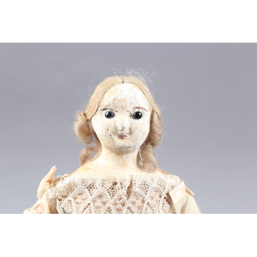 213 - An early 19th century painted wax over papier mache doll with glass eyes, in period dress, 12