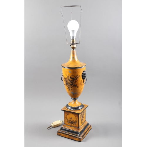 308 - A toleware urn-shaped table lamp with lion mask ring handles and basket of flower decoration, on a s... 