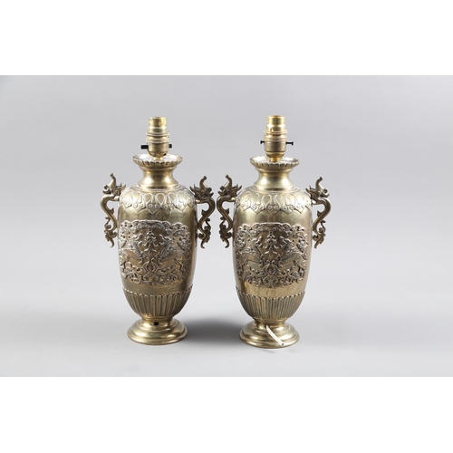 310 - A pair of Japanese brass table lamps with mythical beast decoration and handles, on circular bases, ... 