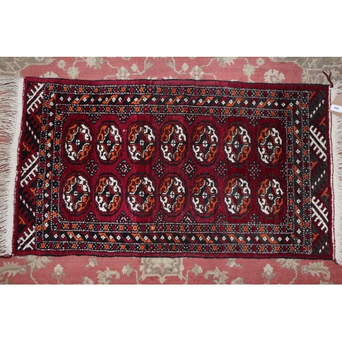 688 - A Bokhara rug with fourteen guls on a plum ground and multi-bordered in shades of black, orange and ... 