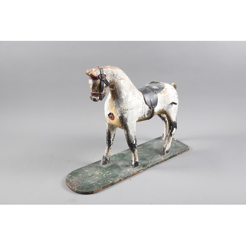 276 - An early 19th century carved wood and painted model horse, on base board, 15