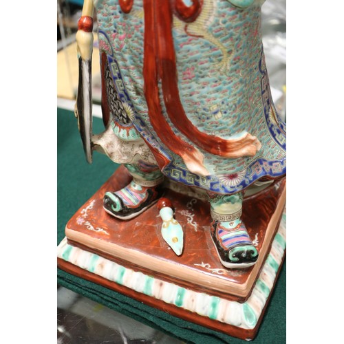 127 - A Chinese porcelain figure of a warrior, seal mark to base, 17 1/2