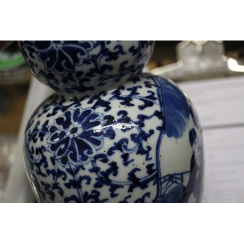 112 - A pair of Chinese blue and white double gourd vases with panelled figure decoration on a flower and ... 