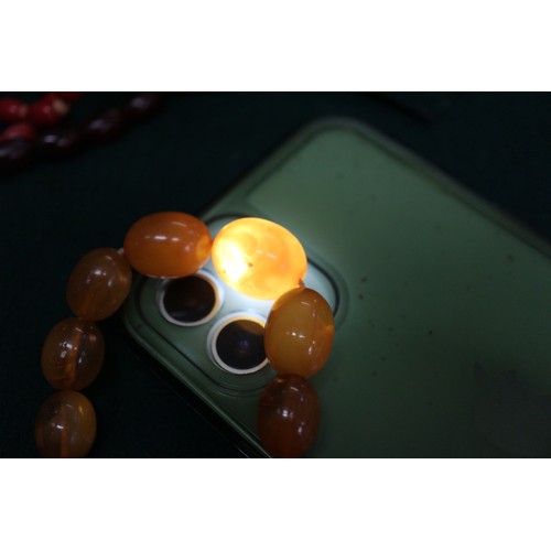 395 - An Art Deco cherry amber Bakelite bead necklace, 15