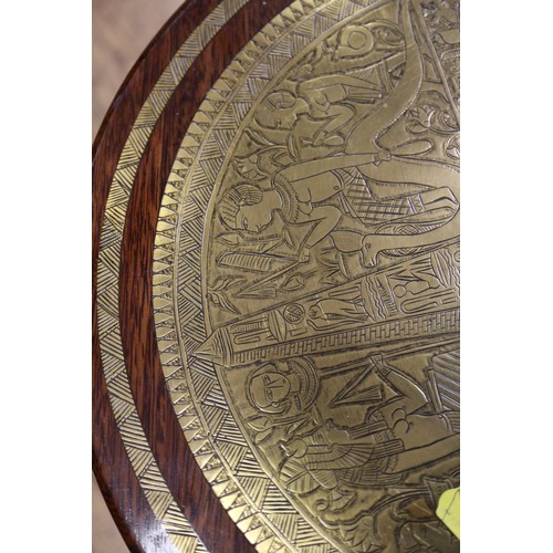 206 - An Egyptian style brass and hardwood circular topped occasional table, on shaped splay supports and ... 