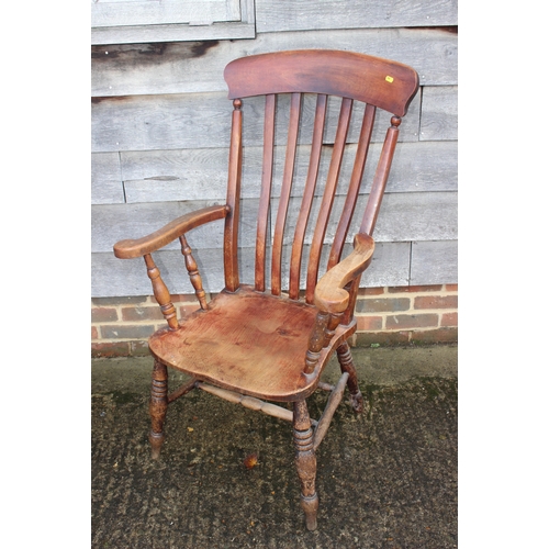 503 - A Windsor farmhouse lath back elbow chair with panel seat on turned and stretchered supports