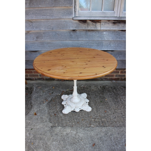 570 - A circular pine top table, on cast iron column and weighted base, 42