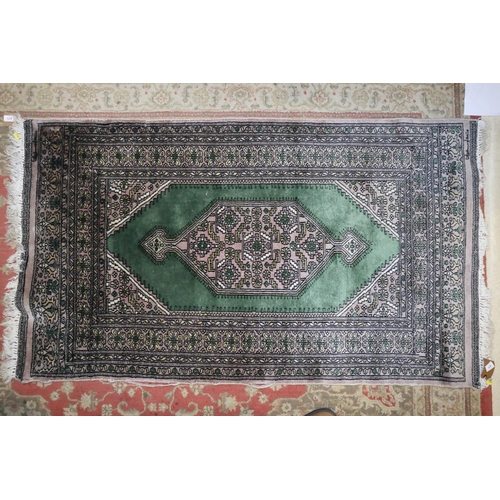 581 - A Bokhara rug with central medallion on a green ground with multi-borders in shades of green, yellow... 