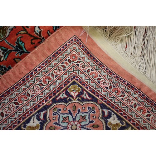 588 - A Kashan/Qum silk wall hanging with central medallion and two lanterns on a red ground and multi-bor... 