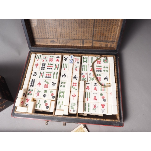 120 - A reproduction Mah-jongg set, in a red lacquered box, two sets of dominoes, a set of playing cards, ... 