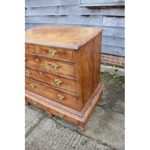 443 - An early 18th century figured walnut and banded chest on stand, the upper section fitted two small d... 