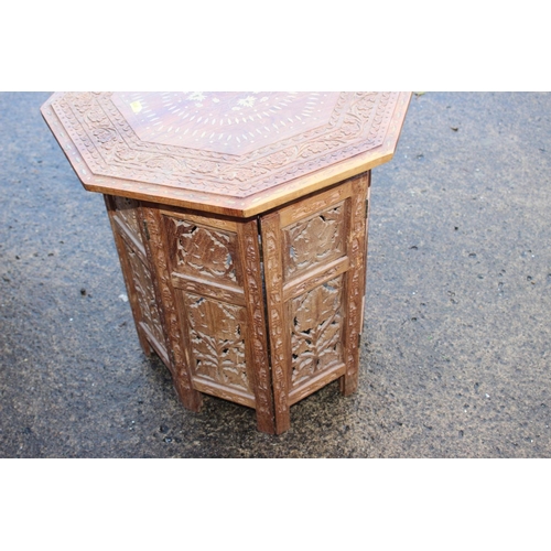 469 - A Kashmir carved and brass inlaid hardwood octagonal occasional table, on folding support, 18