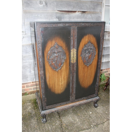 474 - A 1930s Chinese carved hardwood wardrobe enclosed two doors, on shaped supports, 36