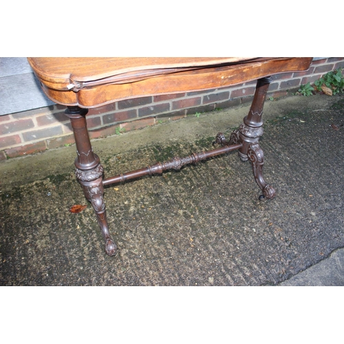 481 - A walnut shaped fold-over top card table, on carved turned and stretchered supports, 37