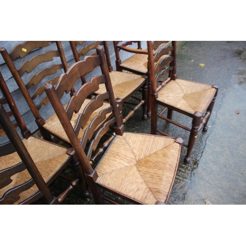 562 - A set of eight ash and oak ladder back dining chairs with rush envelope seats, on turned and stretch... 