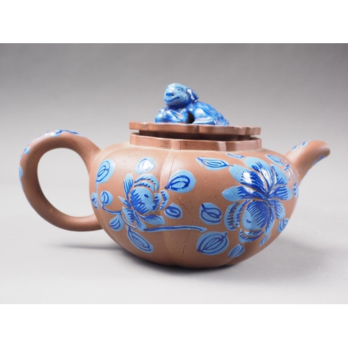 57 - A Chinese Yixing pottery teapot with painted floral decoration and monkey finial, 3 3/4