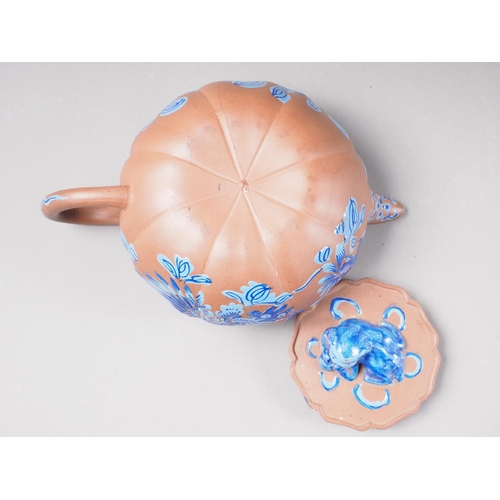 57 - A Chinese Yixing pottery teapot with painted floral decoration and monkey finial, 3 3/4