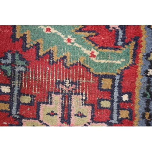 572 - A Caucasian wool rug with central medallion on a blue ground, geometric and floral designs and multi... 