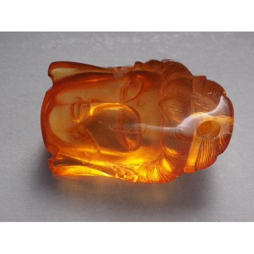 65 - An Oriental carved amber bust of Buddha, partial signature to reverse, 1 3/4