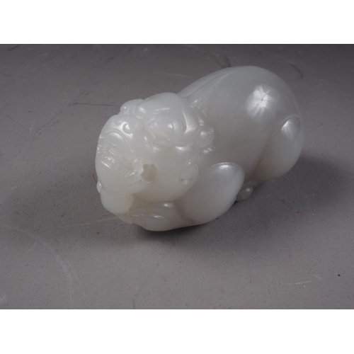 67 - A Chinese carved pale jade model of a mythical beast, 2 3/4