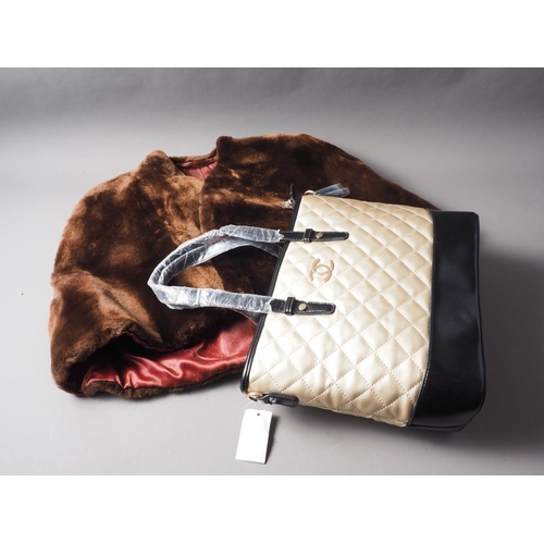 141 - A fur coat, a similar fur cape, various designer style handbags, a leather travelling suitcase, all ... 