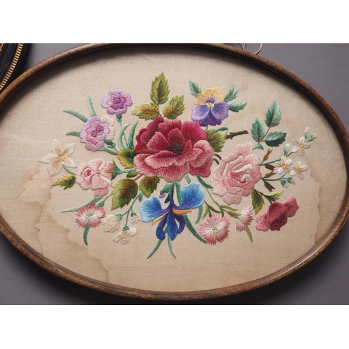 144 - An early 20th century embroidery of floral design, in oval frame, a similar watercolour and an oval ... 