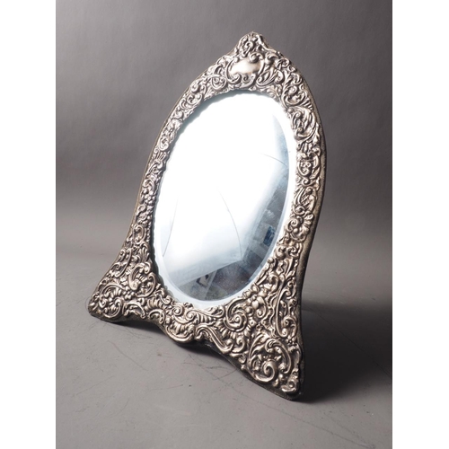 257 - A silver framed easel mirror with scrolled decoration and bevelled plate, 12 1/2