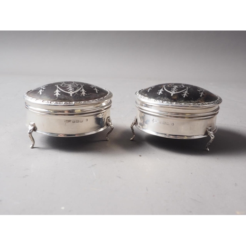 269 - A pair of circular silver and tortoiseshell dressing table hinged boxes, on three cabriole supports,... 