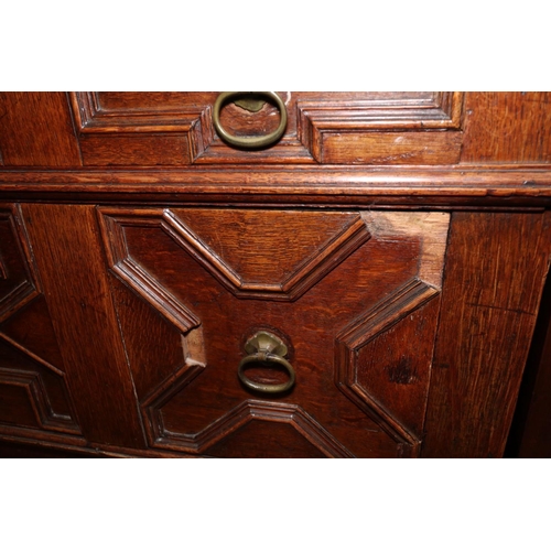 424 - An early 18th century oak chest of four long drawers with fielded panel fronts and ring handles, on ... 